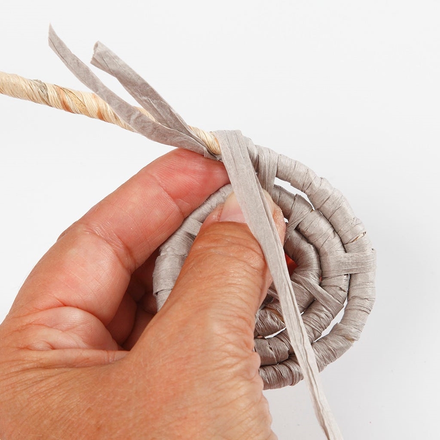 Eine Spirale aus Papierbast wird angefertigt