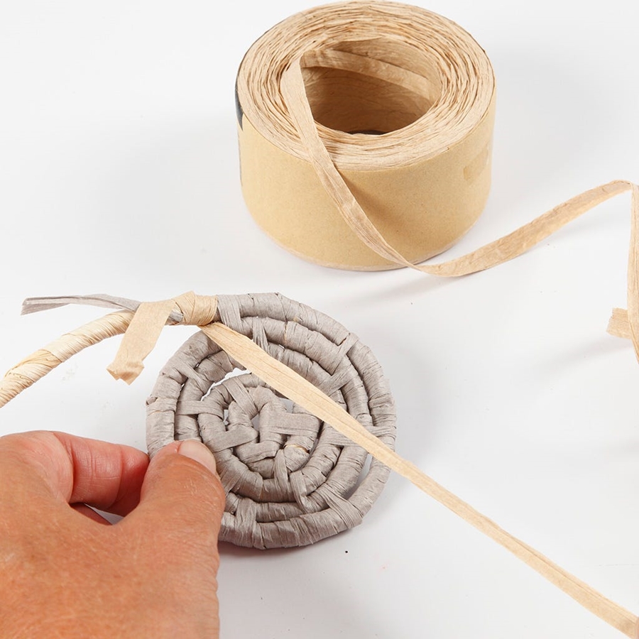 Eine Spirale aus Papierbast wird angefertigt