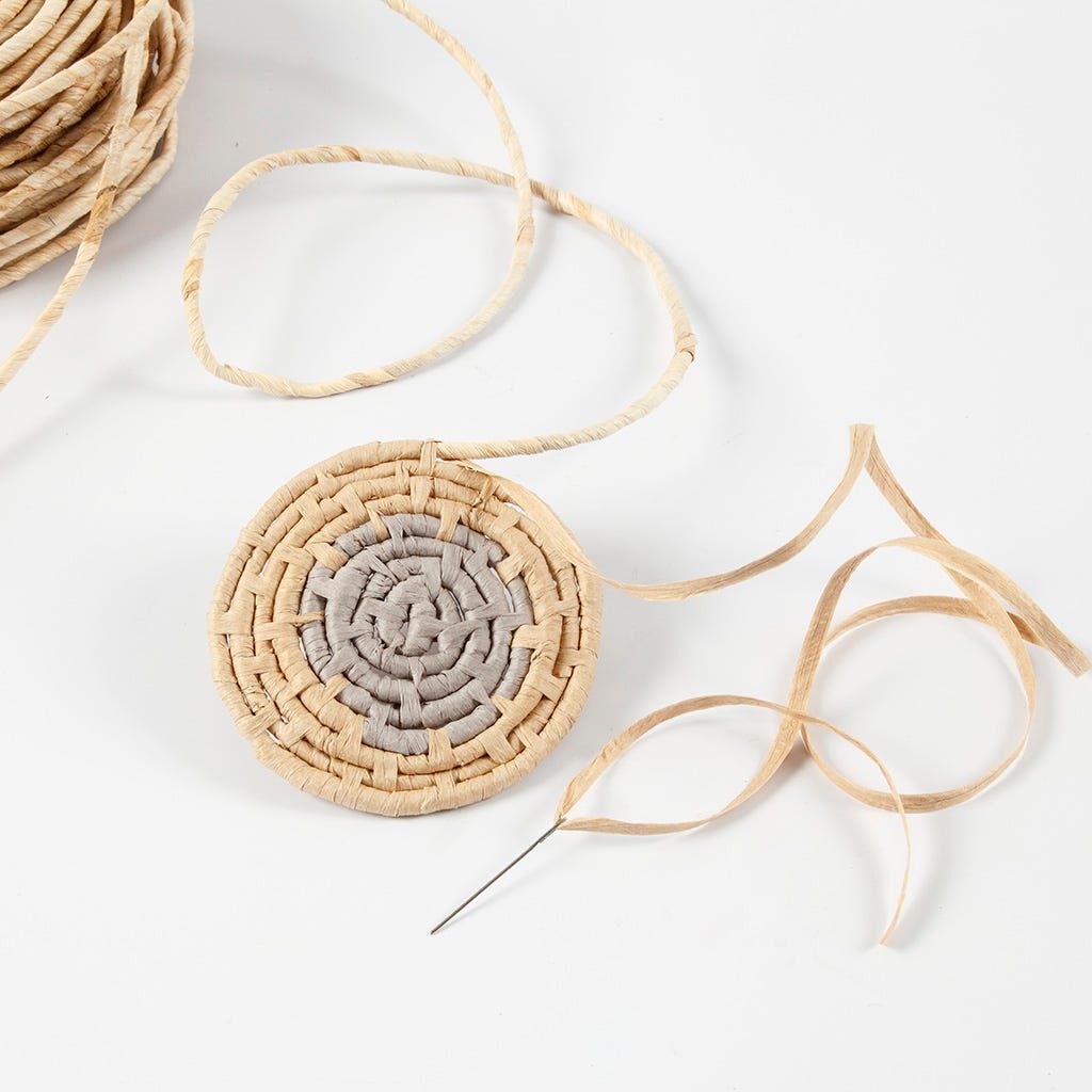 Eine dritte Farbe Papierbast wird für den Korb angesetzt