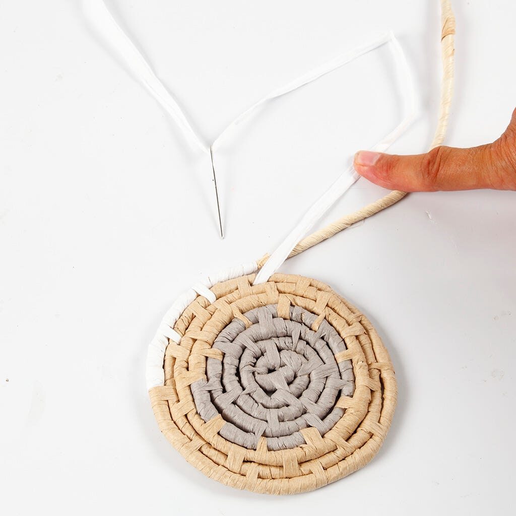 Eine dritte Farbe Papierbast wird für den Korb angesetzt